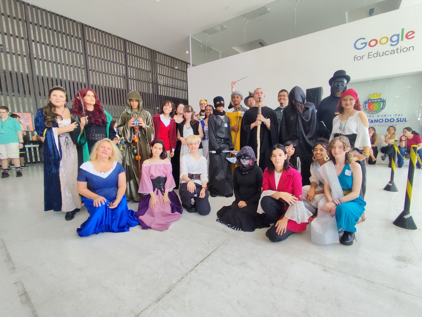 Alunos e professores caracterizados com trajes de época na Feira Medieval de 2024, no lobby do Google for Education